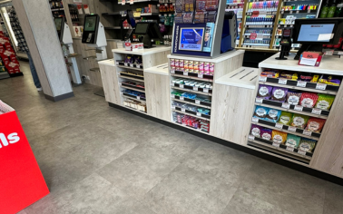 Zone des caisses d'un supermarché Spar, revêtue de dalles de sol LVT Ecotile Infinity à l'aspect béton