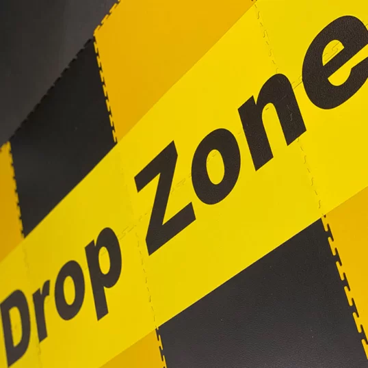 Area marked out as a drop zone on ecotile floor in yellow and black with floor markings