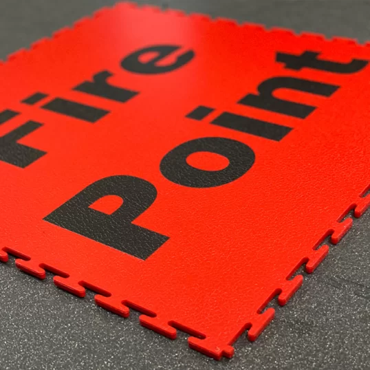 Image of a red Ecotile with Fire Point lettering marked out on the floor