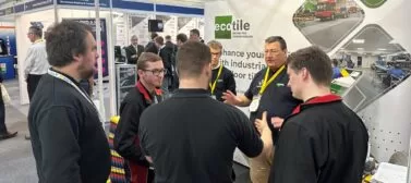 Visitors to the Ecotile exhibition stand discuss interlocking floor tiles during the Southern Manufacturing and Electronics show