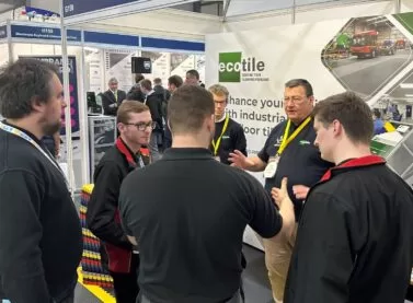 Visitors to the Ecotile exhibition stand discuss interlocking floor tiles during the Southern Manufacturing and Electronics show