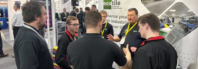 Visitors to the Ecotile exhibition stand discuss interlocking floor tiles during the Southern Manufacturing and Electronics show