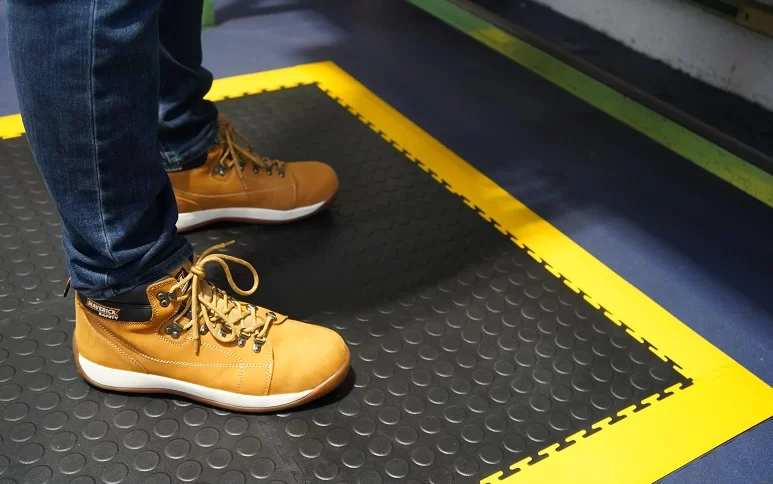 Wprkstation created using ergonomic raised disc Ecotile anti-fatigue floor tiles and compatible yellow ramps