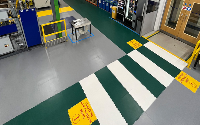 Passage piéton vert et blanc avec des panneaux d'avertissement « Regardez des deux côtés »