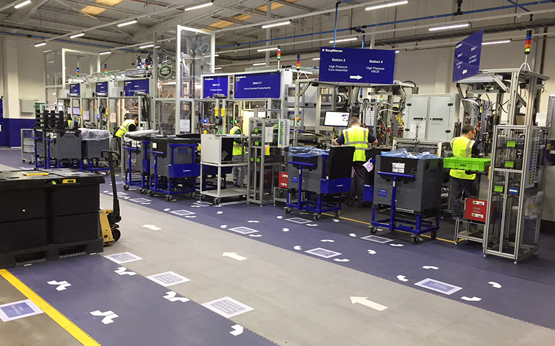 Carrelage « ecotile » gris clair et bleu foncé sur le sol d'une usine