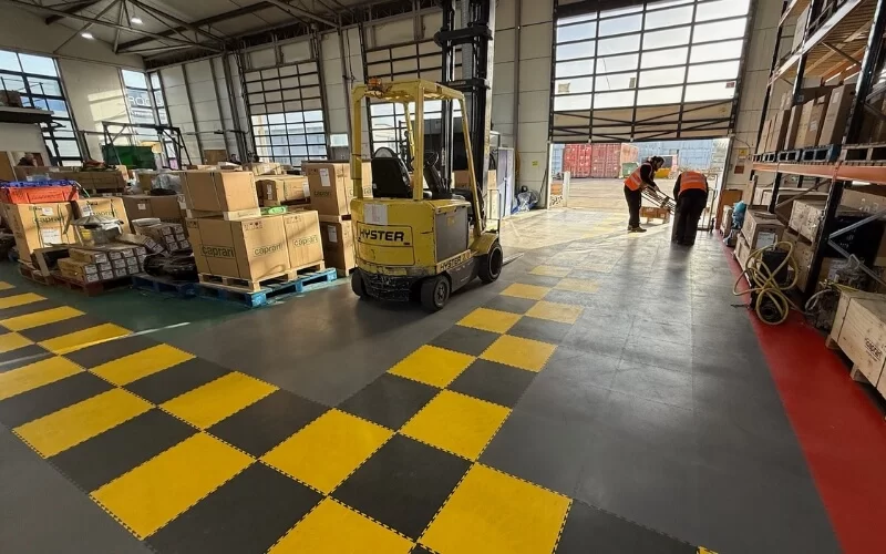 Caprari Pumps UK warehouse demonstrating 5S methodology for their workplace organisation, by using different coloured ecotile floor tiles to create work flows and mark designated racking areas