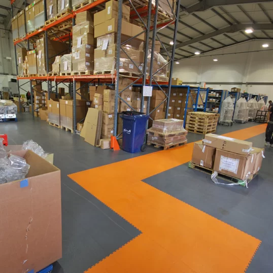 Custom branded orange Ecotile walkways in warehouse building