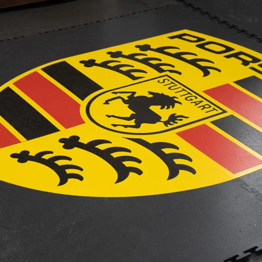 Porsche logo printed across four Ecotile flooring tiles, showing how floor can be used to create custom floor graphics