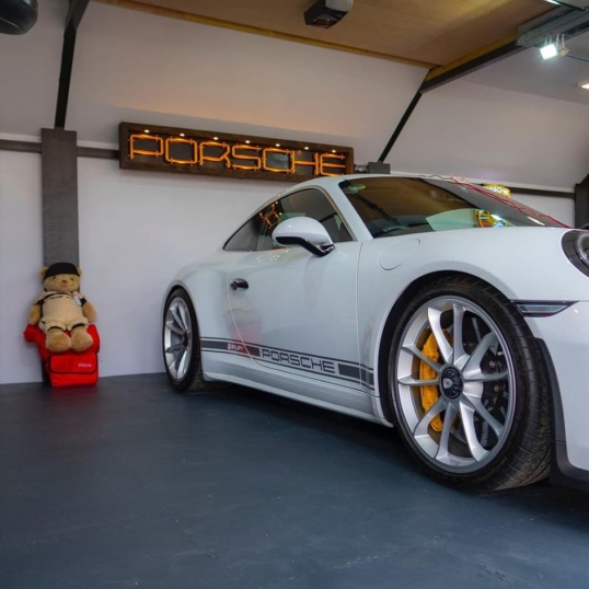 Vue de profil d'une Porsche 911 sur un sol en dalles de PVC emboîtables de couleur grise