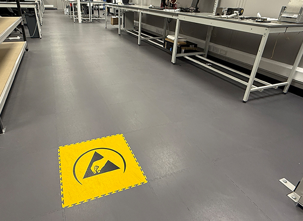 Image of ESD floor with racking and benches, complete with an embedded ESD safety logo in the floor