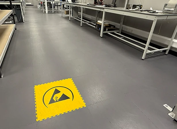 Image of ESD floor with racking and benches, complete with an embedded ESD safety logo in the floor