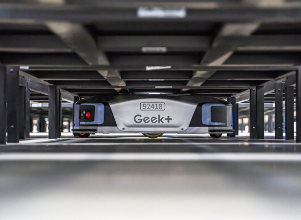 Geek+ robot under warehouse shelving at Yunex logistics
