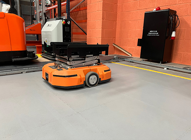 Orange AGV robotic system being tested on an Ecotile floor tile