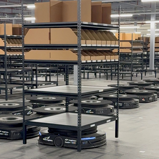 Image of AGV robot in Yunex logistics, with a full shelf on interlocking floor tiles